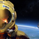 An astronaut stands in front of a hexagonal space station in space.
